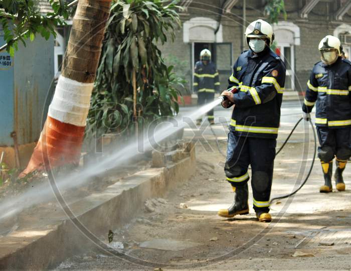 Members of a municipal fire brigade spray disinfectant inside the Police Headquarters area at Crawford market, during the 21- day nationwide lockdown to limit the spreading of coronavirus disease (COVID-19) in Mumbai, India on March 28, 2020.