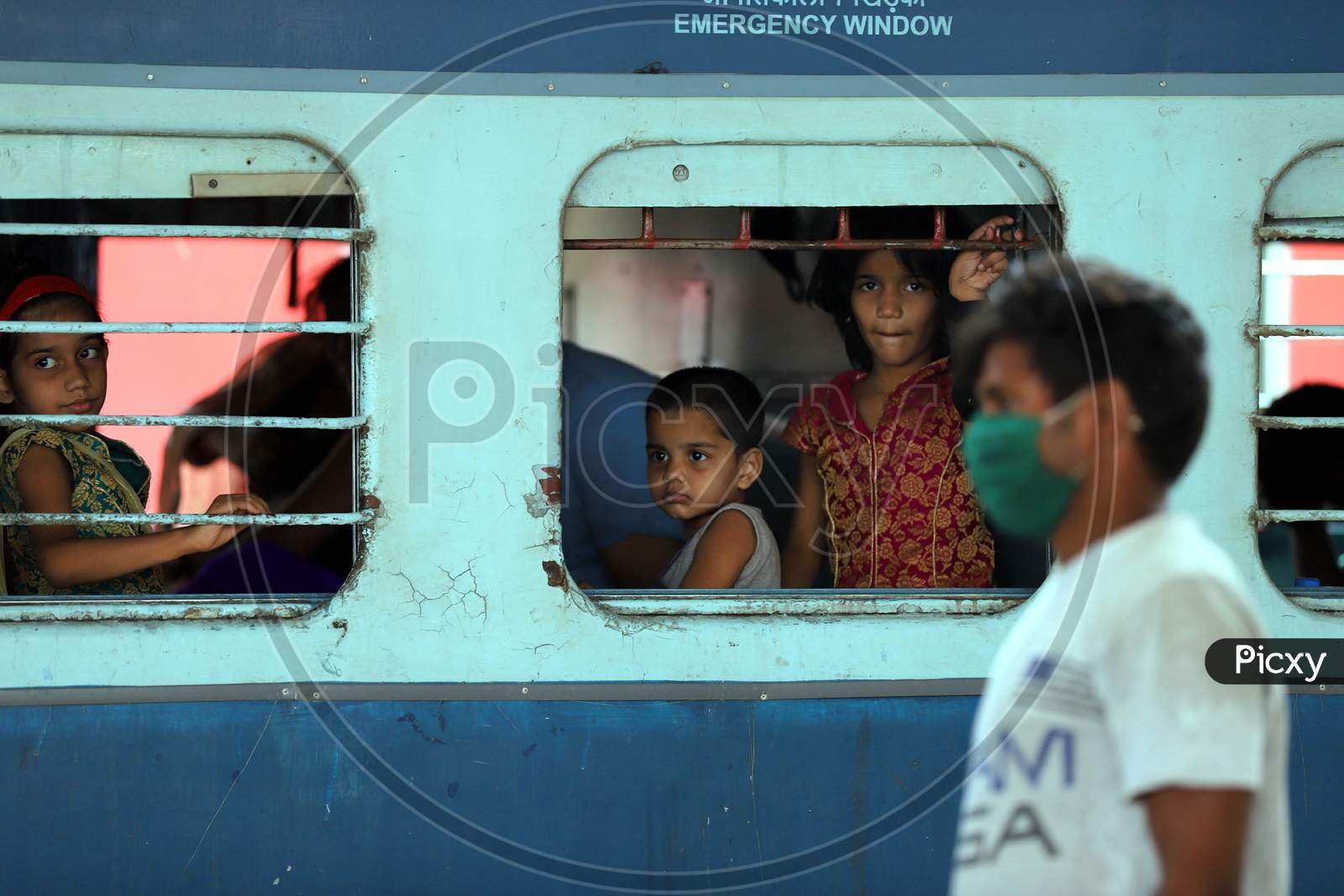 Migrant children peep out from the window of a Special Train During Extended Nationwide Lockdown Amidst Coronavirus Or COVID-19 Pandemic in Prayagraj
