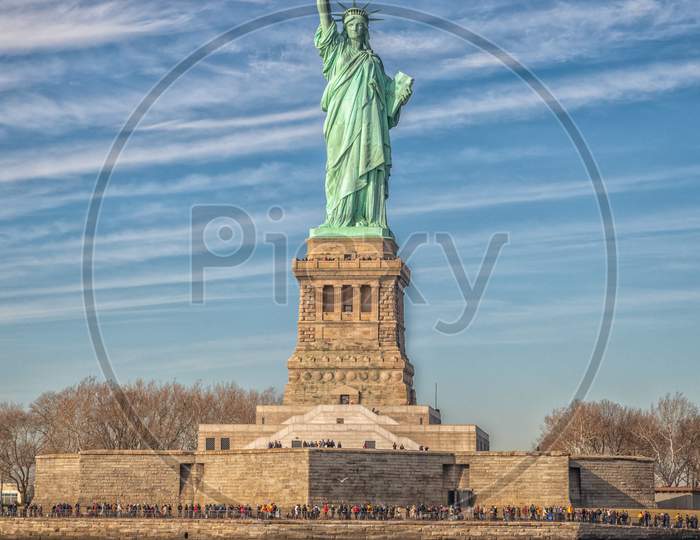 The Statue of Liberty in New York City USA daylight view with clouds in sky