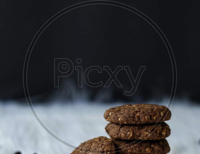 Chocolate And Oats Cookies With Chocolate Chips And Chocolate Pieces On A White Fur Background