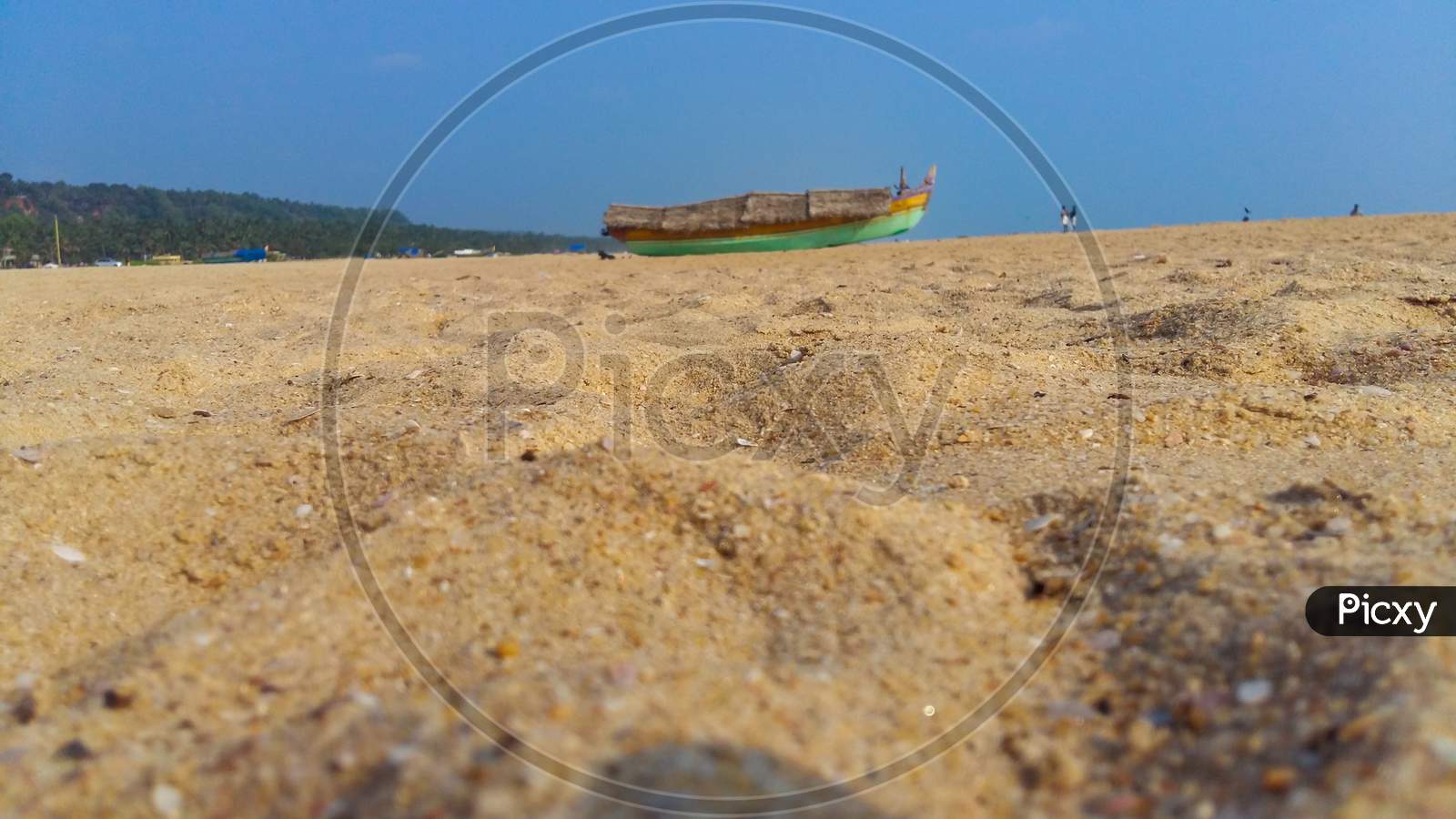 Landscape Image Of Sandy Azhimala Beach In Trivandrum, Kerala, India With A Unfocused Parked Fishing Boat On Sand.