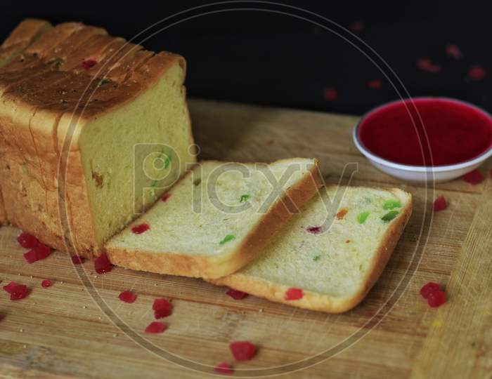 Fruit Bread With Cherry On A Wooden Plank With Tutti Frutti And Fruit Jam
