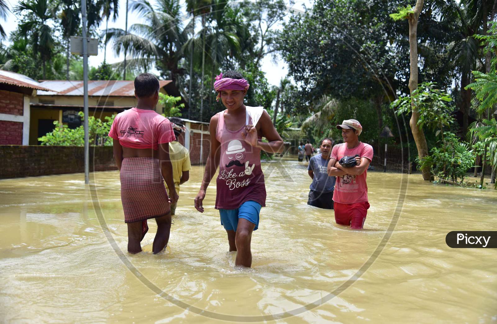 Villagers Wade Through a Flooded street At Kampur In Nagaon District Of Assam On May 29,2020.