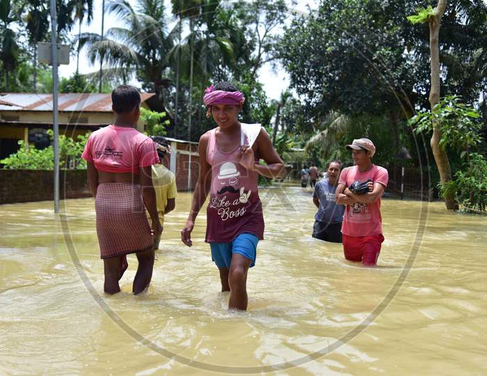 Villagers Wade Through a Flooded street At Kampur In Nagaon District Of Assam On May 29,2020.