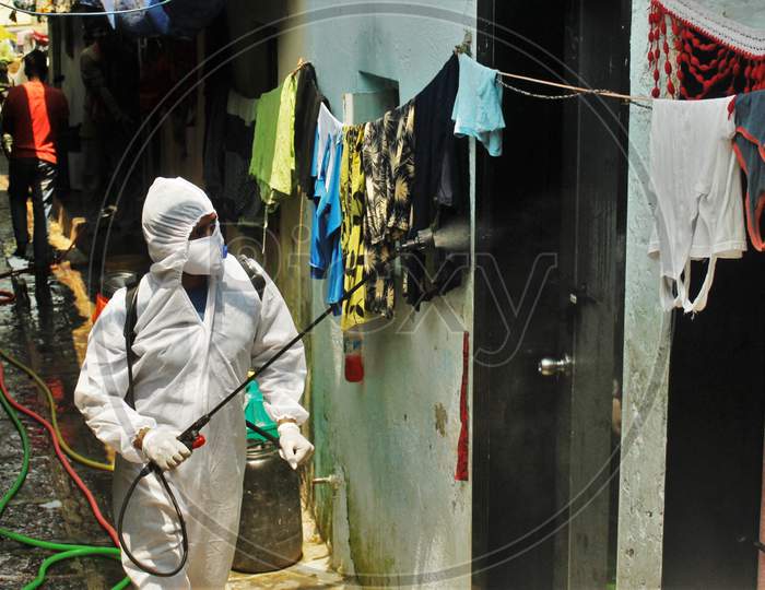 A worker wearing a protective suit disinfects a slum area as a preventive measure against the spread of coronavirus disease (COVID-19) in Mumbai, India on March 28, 2020.