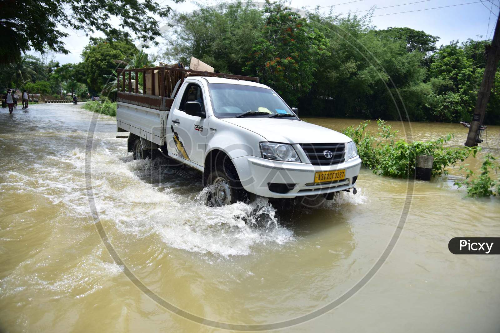 Vehicles Moving On Road Through Flood Waters In Kampur In Nagaon District Of Assam ,India
