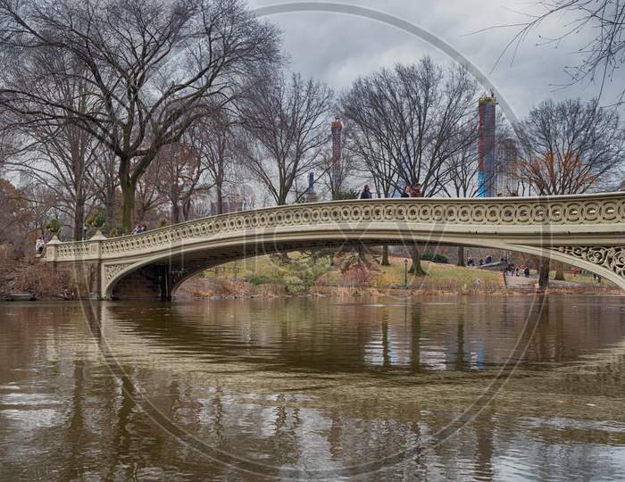 The bow bridge in central park, New York city daylight view with reflection in water , clouds and trees