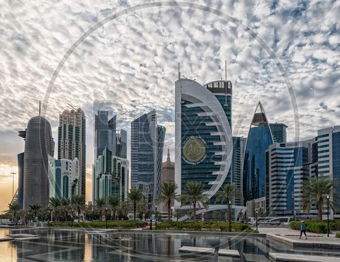 Doha, Qatar  Skyline daylight view from Sheraton park with reflection in the water and clouds in sky in background