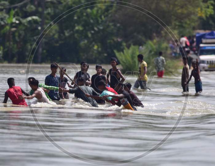 Villagers Try To Cross A  Flooded Street at Jamunamukh  Village In Hojai District Of Assam On May 29,2020