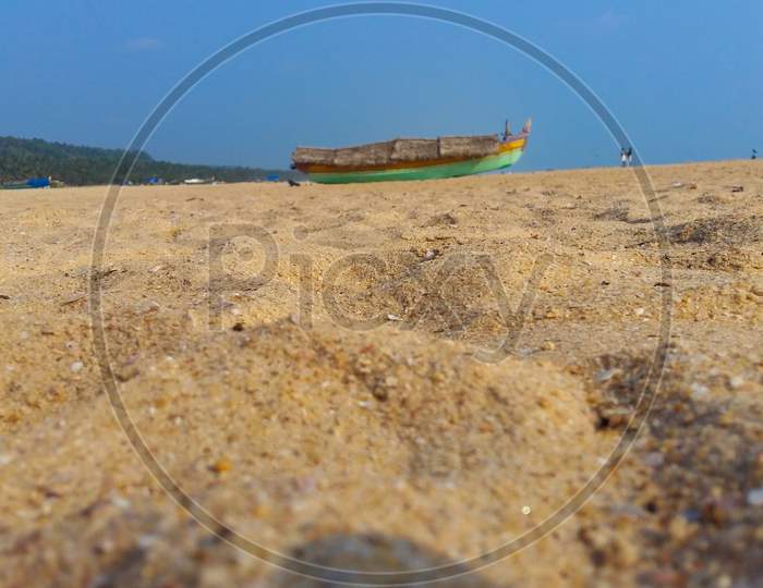 Landscape Image Of Sandy Azhimala Beach In Trivandrum, Kerala, India With A Unfocused Parked Fishing Boat On Sand.