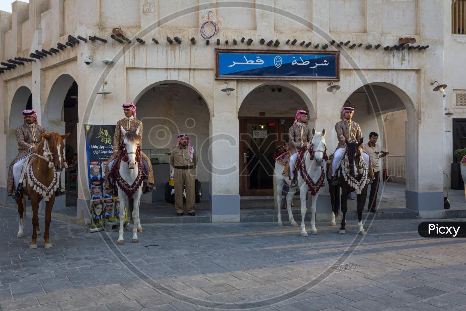 Old police station in Souk Waqif Doha Qatar daylight view with traditional guards riding horses in front of it
