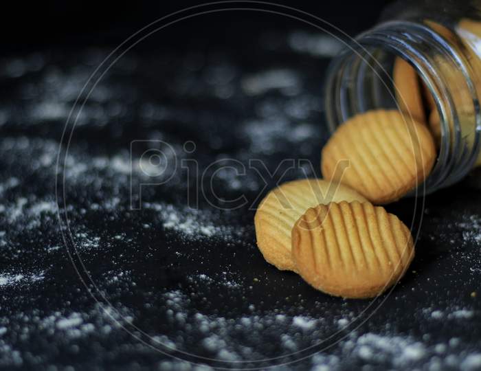 Vanilla Cookies Falling Out From A Cookie Jar .