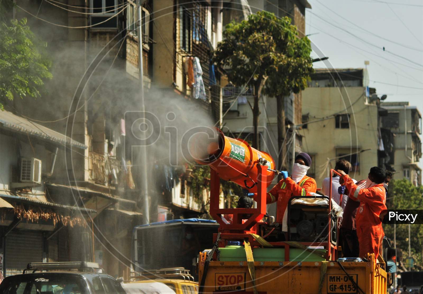 Workers use a blower to spray disinfectant to decontaminate a street during a 21-day nationwide lockdown to limit the spreading of coronavirus disease (COVID-19) in Mumbai, India, April 4, 2020.