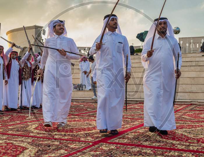 Qatar traditional folklore dance (Ardah dance)  in Katara cultural village, Doha- Qatar with the Amphitheater in the background