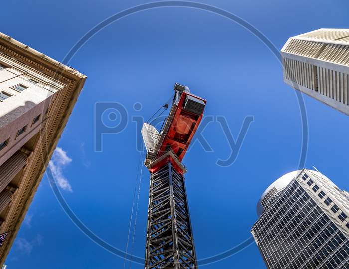 Sydney, Australia - 10th February 2020: A german photogropher taking pictures of a park with a view to the Sydney Tower and a construction crane in the foreground.