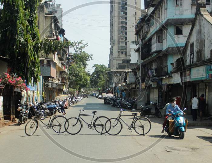 A man rides past a line of cycles erected across a road, as a blockade, during a 21-day nationwide lockdown to slow the spread of the coronavirus disease (COVID-19), in Mumbai, India, April 7, 2020.