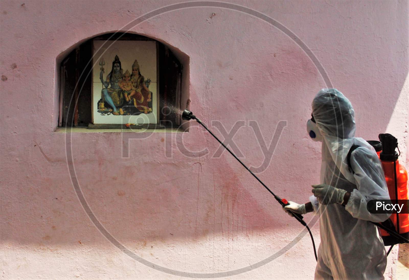 A worker wearing a protective suit disinfects a temple as a preventive measure against the spread of coronavirus disease (COVID-19) in Mumbai, India on March 28, 2020.