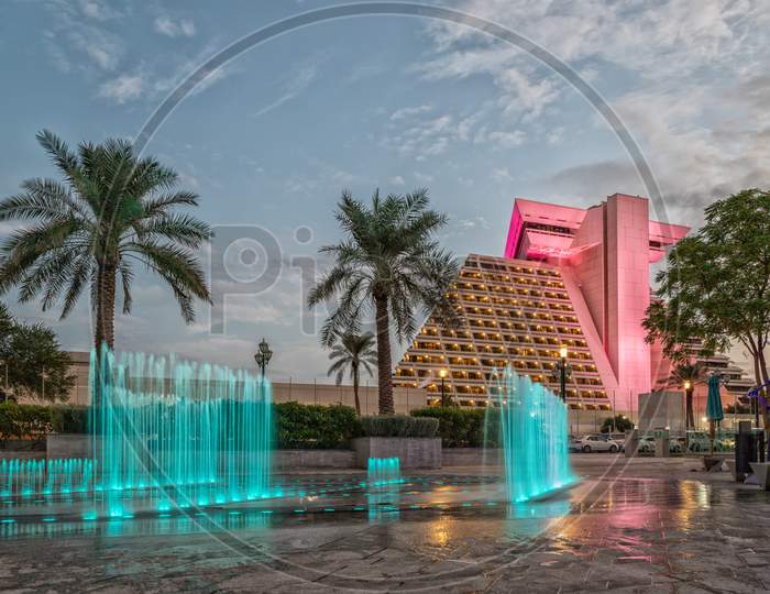 Sheraton Al Doha hotel  in Qatar exterior daylight view with illuminated  fountain in foreground and clouds in sky in background