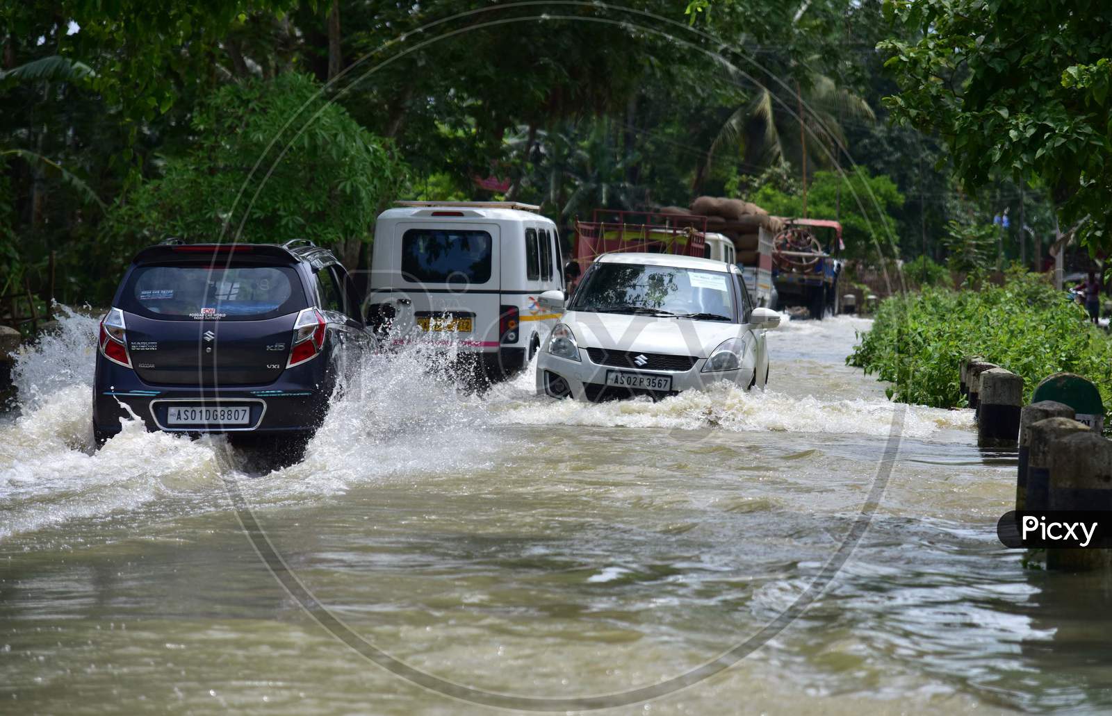 Vehicles Moving On Road Through Flood Waters In Kampur In Nagaon District Of Assam On May 29,2020.