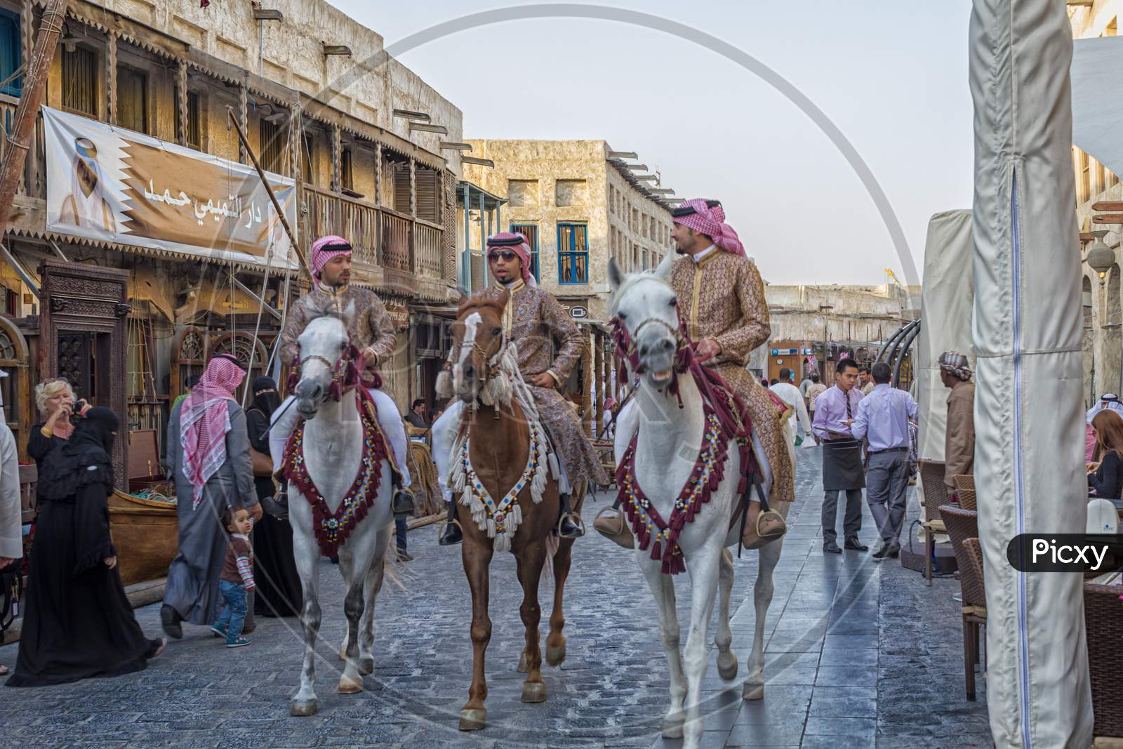 Souk Waqif in Doha Qatar main street day light view with traditional guards riding horses and people walking