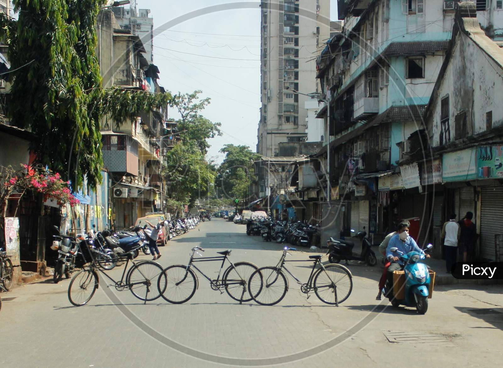 A man rides past a line of cycles erected across a road, as a blockade, during a 21-day nationwide lockdown to slow the spread of the coronavirus disease (COVID-19), in Mumbai, India, April 7, 2020.