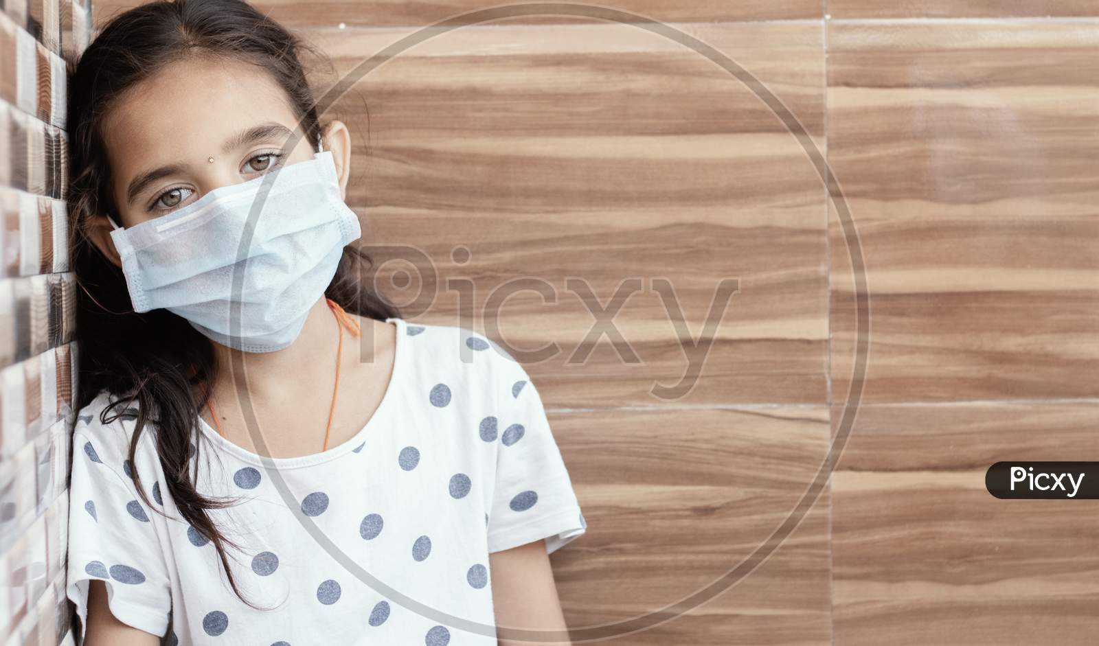 Concept Of Ptsd Or Post-Traumatic Stress Disorder After Covid-19 Or Coronavirus Pandemic - Young Teenager Girl With Medical Mask Wearing Sat By Leaning On Well In Sad, Fear, Or Anxiety.