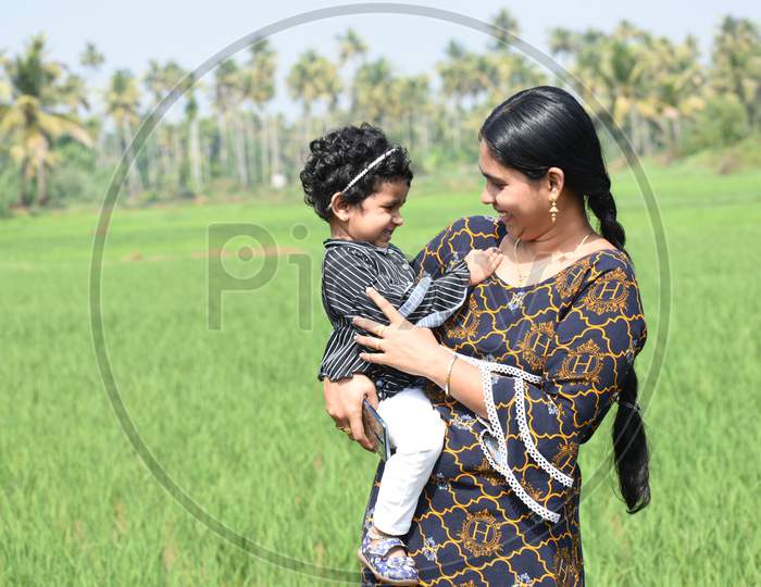 Mothers Day Special.Mother And Little Girl Felling Happy,Paddy Field In The Background.