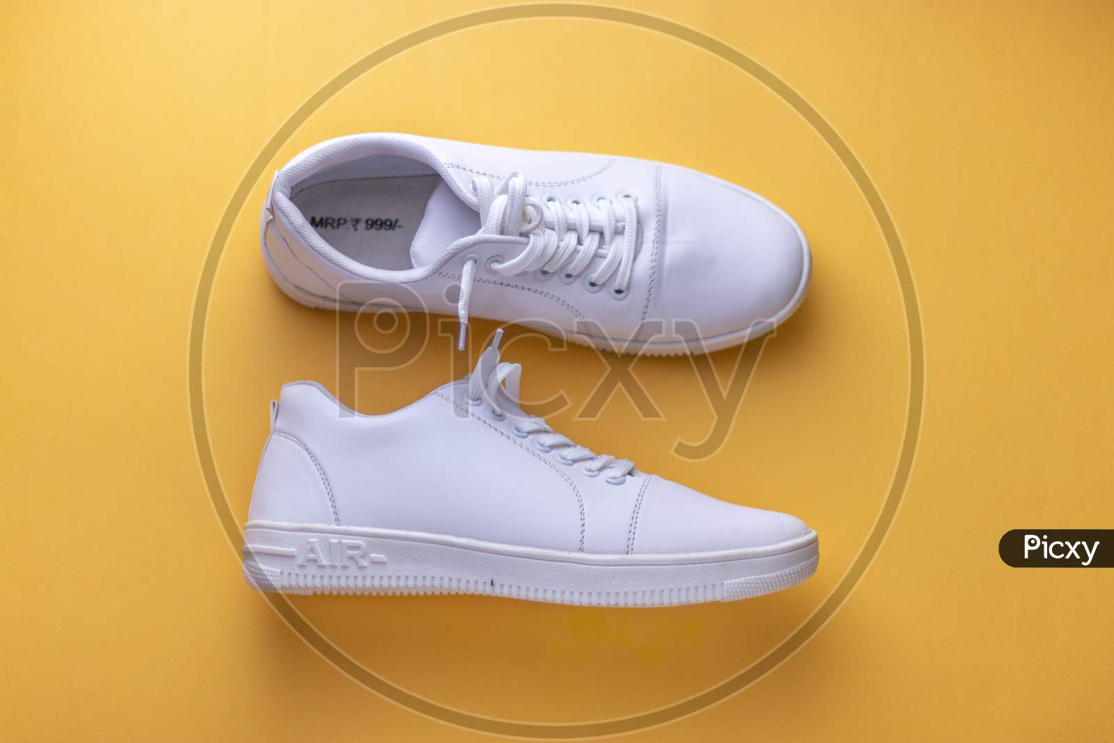 White sneakers on light yellow colour background, flat lay top view minimal background.