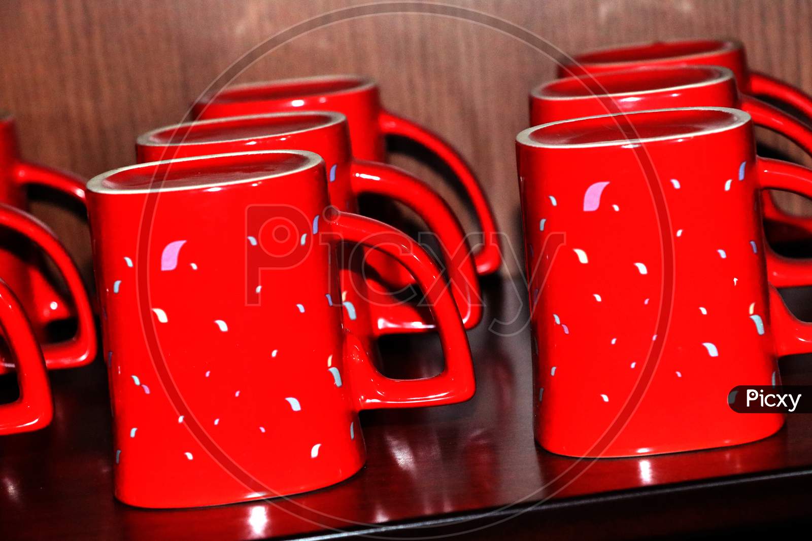 Red color coffee mug for the refreshment is waiting at showcase