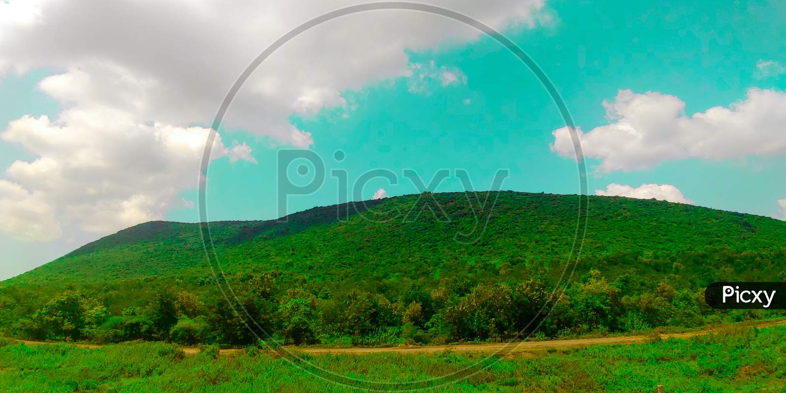 Landscape view of a small hill with a cloudy sky