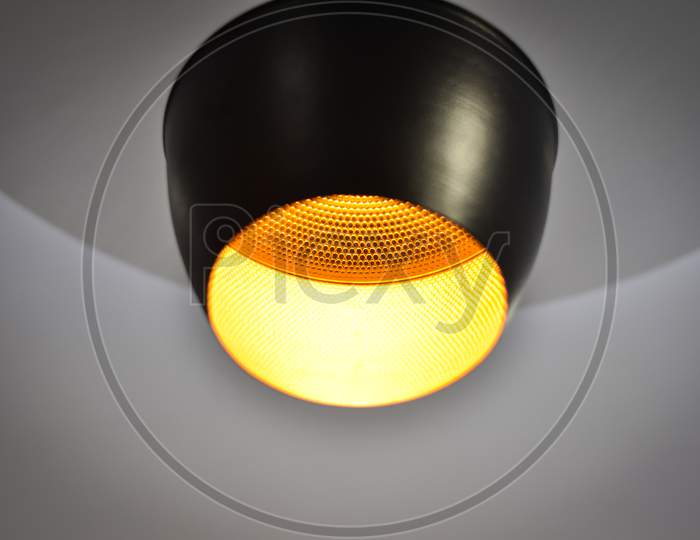 Orange lamp light hanging on a wall with white background