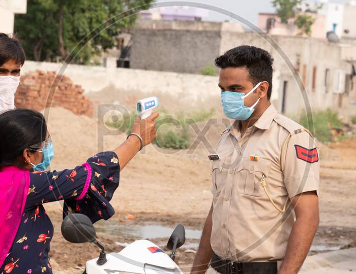 Ambala City, Haryana/India -04/30/2020  Health workers checking body temperature of police during Routine Checkup to avoid covid infection in   Police