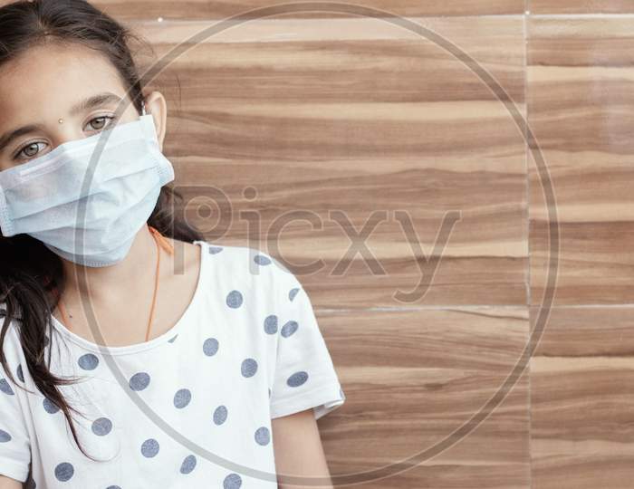 Concept Of Ptsd Or Post-Traumatic Stress Disorder After Covid-19 Or Coronavirus Pandemic - Young Teenager Girl With Medical Mask Wearing Sat By Leaning On Well In Sad, Fear, Or Anxiety.