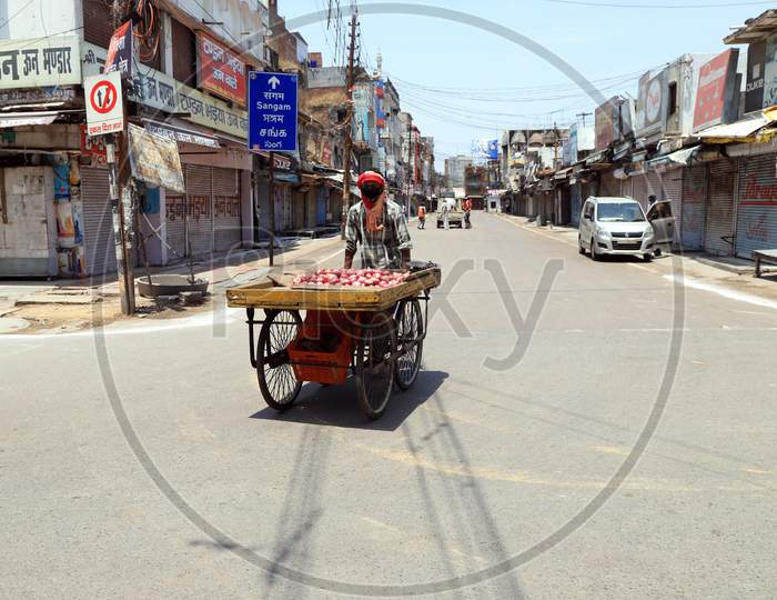 A vendor selling onion on an empty road during a government-imposed nationwide lockdown as a preventive measure against the Coronavirus, in Prayagraj, May 3, 2020.