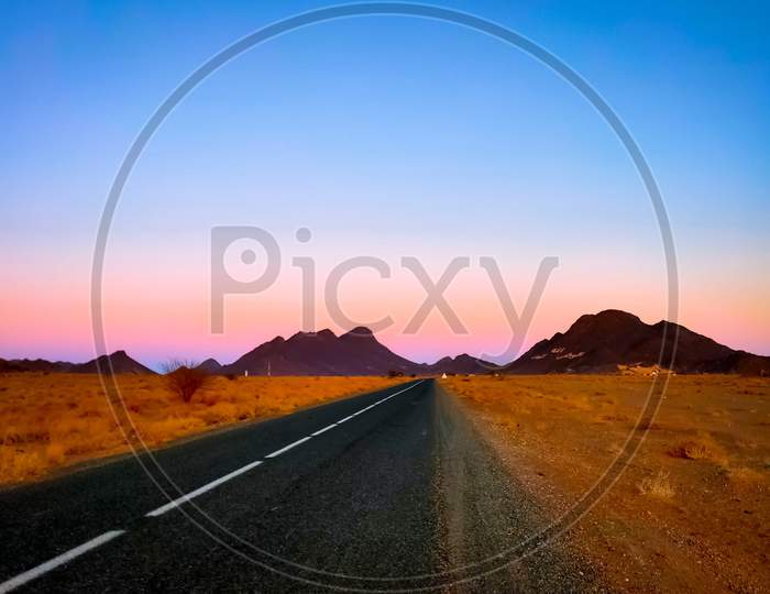 Empty road across the desert through mountains
