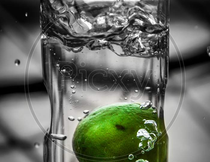 Fresh green lemon in water splash, Lemon water splash in glass, Refreshment drink in summer