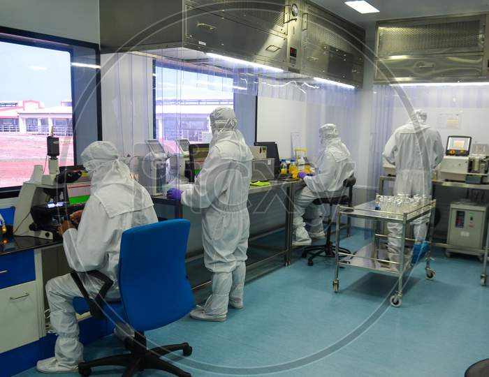 Scientists in protective coverall doing research at a laboratory in India, while maintaining quality standards and protocols.