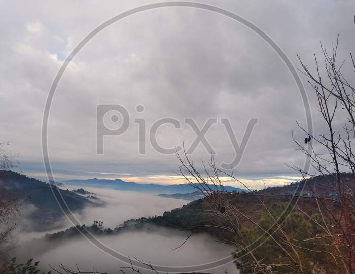 Lovely view of evening landscape with mountains covered with fog in hilly area of Himachal pradesh, India