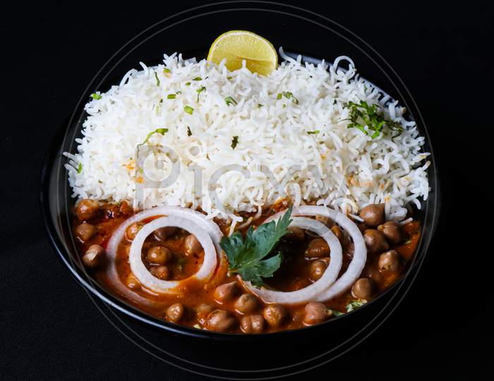 Indian food item chole chawal with onion rings