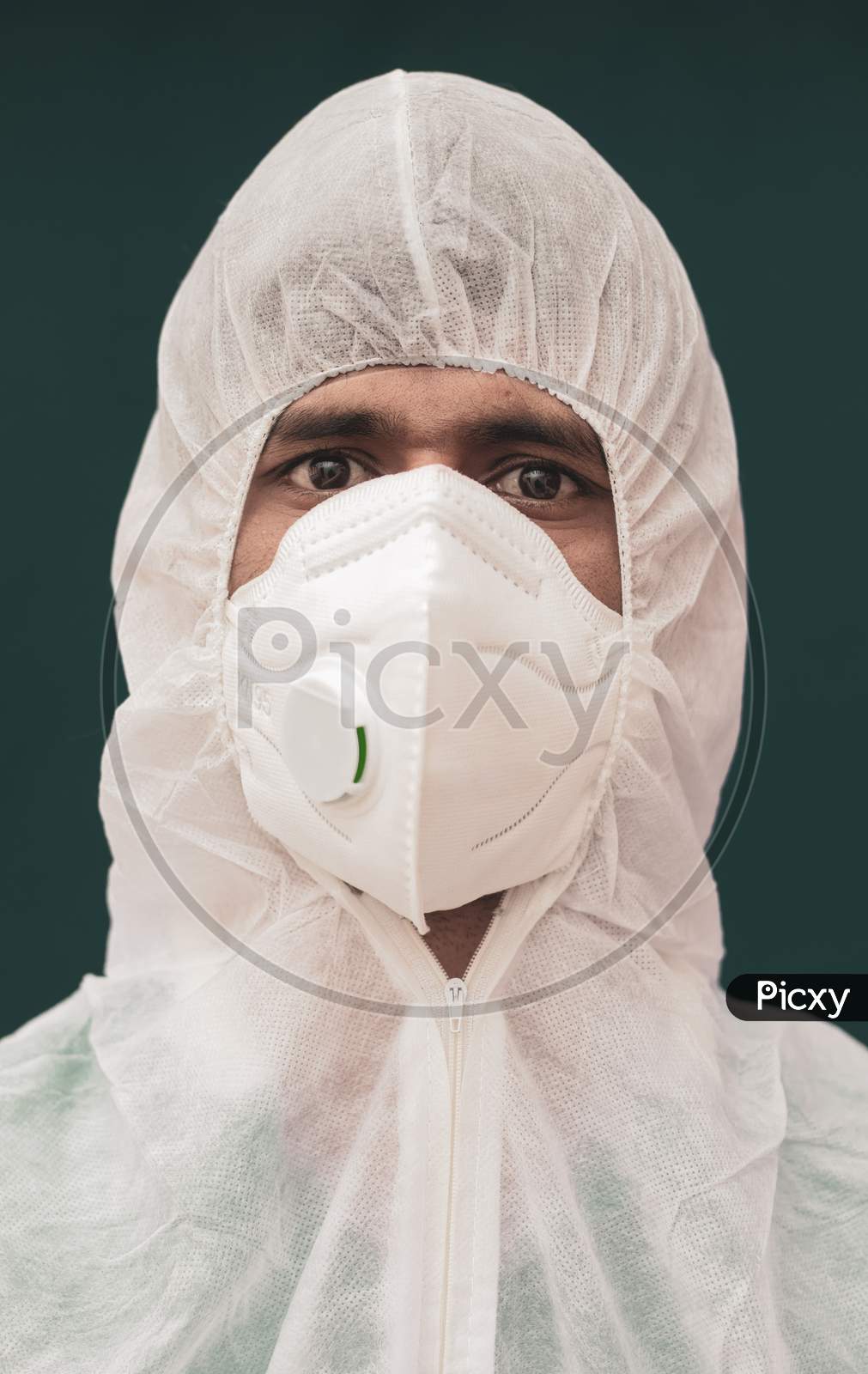 Close Up Portrait Of Doctor With Protective Suite And Medical N95 Face Mask Looking At Camera - Concept Of Doctors At Coronavirus Or Covid 19 Screening Process.