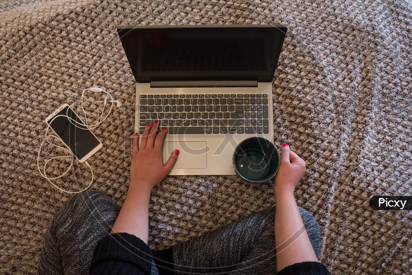 Working home concept. A women with laptop smartphone and a cup of tea working at home. Workspace at home.