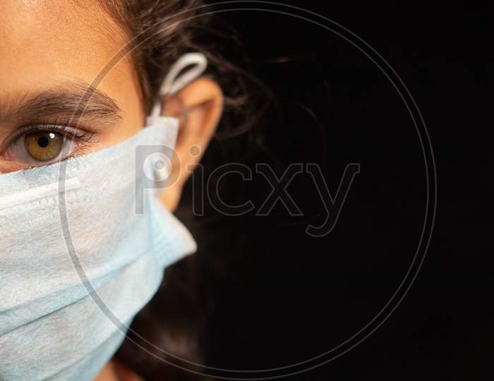 Young Girl Child With Medical Mask Wearing, Protection Against Covid 19 Or Coronavirus Pandemic On Black Background With Copy Space.
