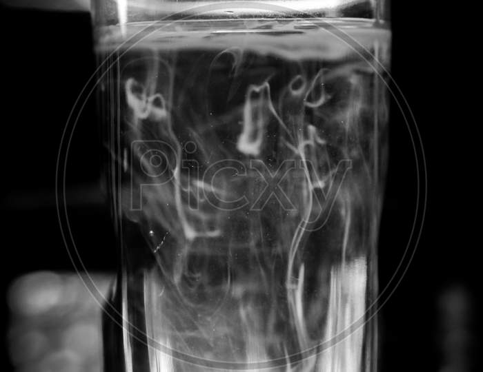 Chemical solution in water, chemical composition creates smokey pattern into the water, a medicine testing in a medical lab, blurry images with selective focus point on smokey effect