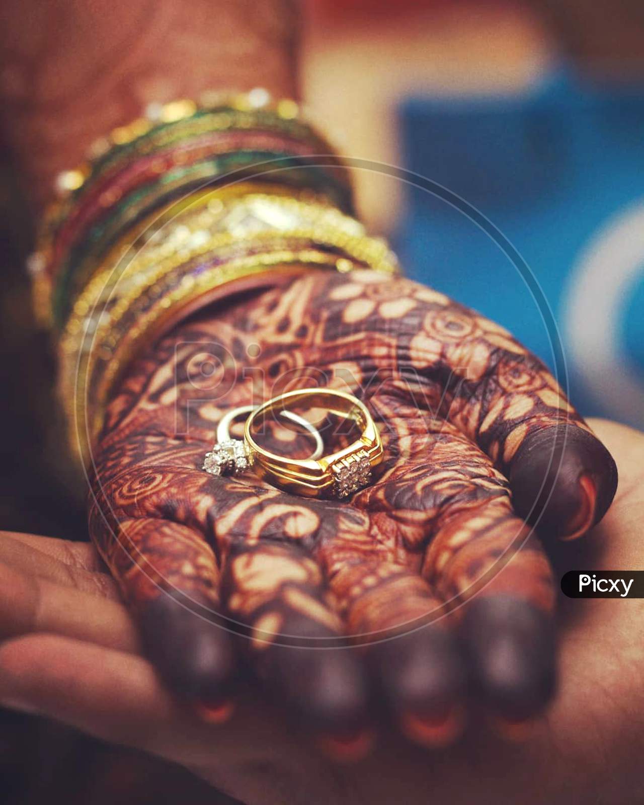 Engagement rings in hands of bride and groom