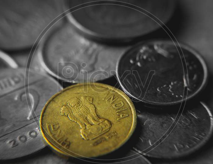 Coins of Indian currency rupee (INR) . Golden five rupee , ten rupee coins and silver one rupee coins. Selective focus on coins with blurred background