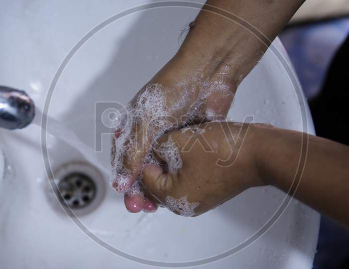 Closeup Of Person Washing Hands Using Liquid Soap