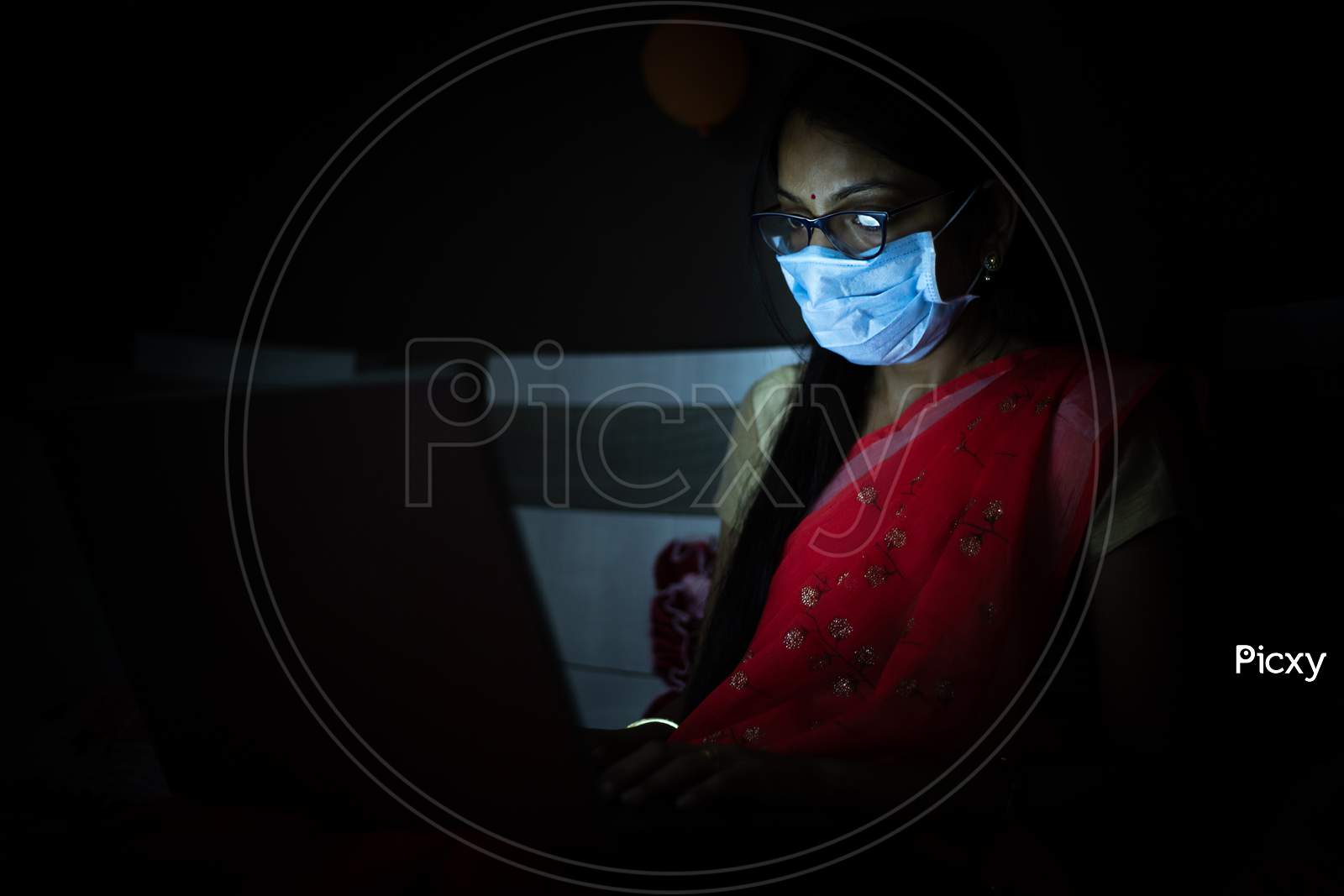 Young Indian Woman Wearing Mask Working On Her Laptop Late Night, Freelancer Working From Home. Coronavirus,Covid-19. Stay Home Stay Safe, Woman In Quarantine.