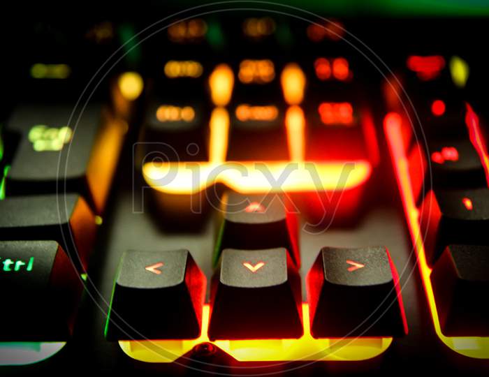 Gaming keyboard with RGB lighting for desktop computer, switches of keyboard are glowing with colorful back lights