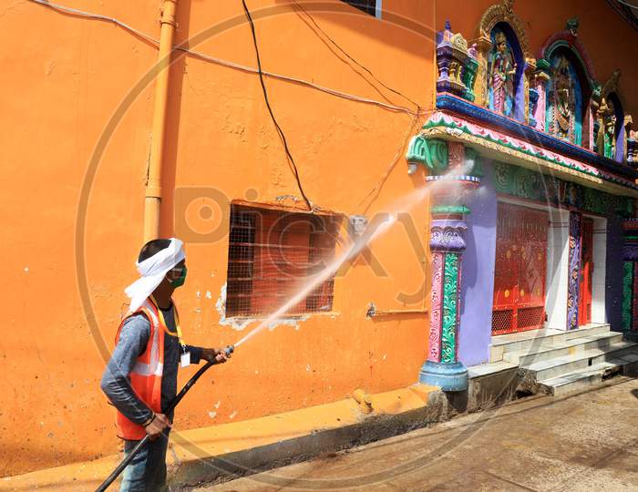 A worker of municipality sanitizes a temple during a government-imposed nationwide lockdown as a preventive measure against Coronavirus,  in Prayagraj, May 3, 2020.