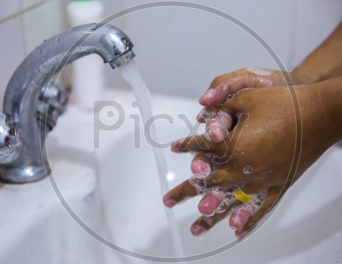 Washing The Hands In Bathroom To Prevent Getting Sick